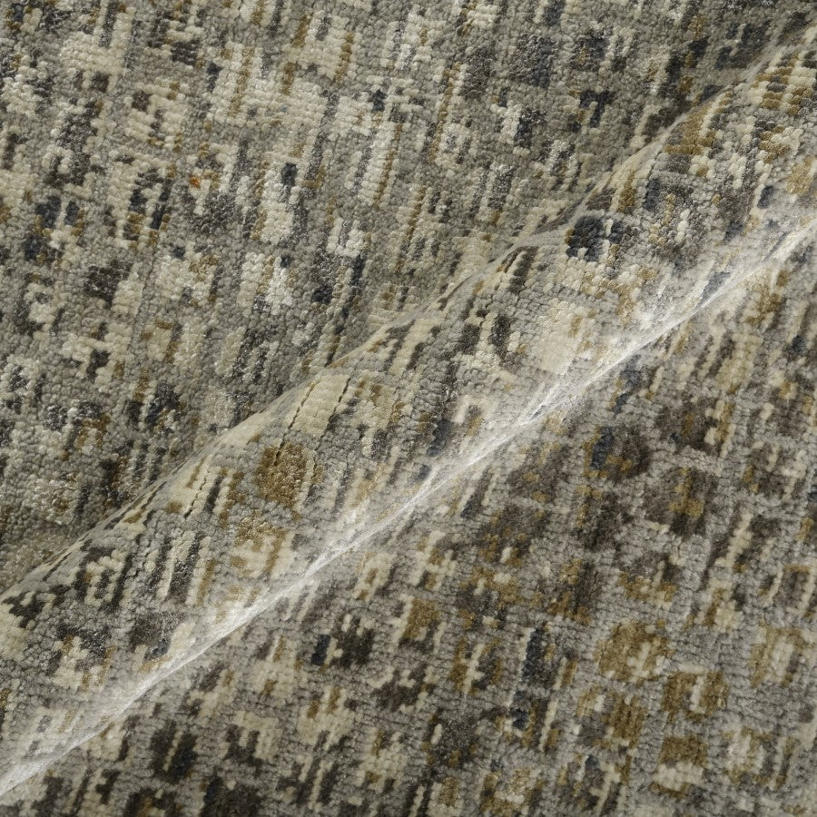Close-up of a textured fabric with a geometric pattern in brown, beige, and black.