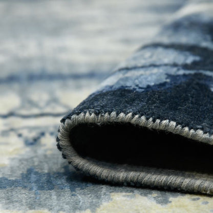 Close-up of a textured blue and gray rug with a patterned edge.