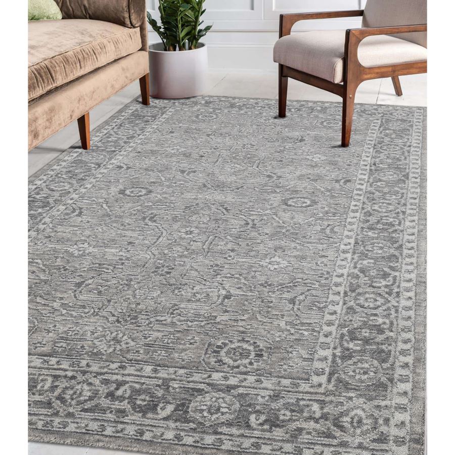 Gray patterned rug in a living room setting with furniture and decor.