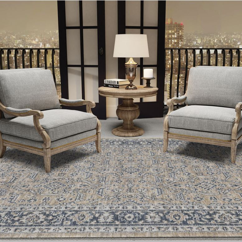 Two gray armchairs with wooden frames on a patterned rug in a room with a cityscape view.