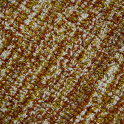 Close-up of a textured fabric with brown, white, and yellow pattern