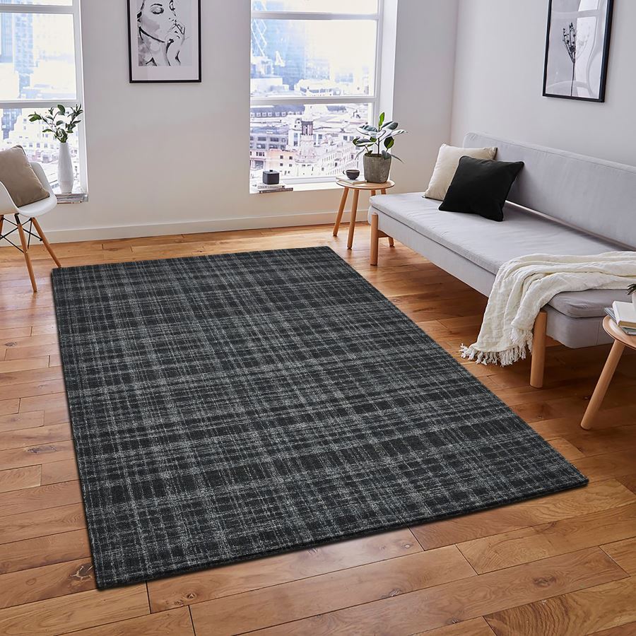 Living room with a dark gray plaid rug, sofa, and decor elements.