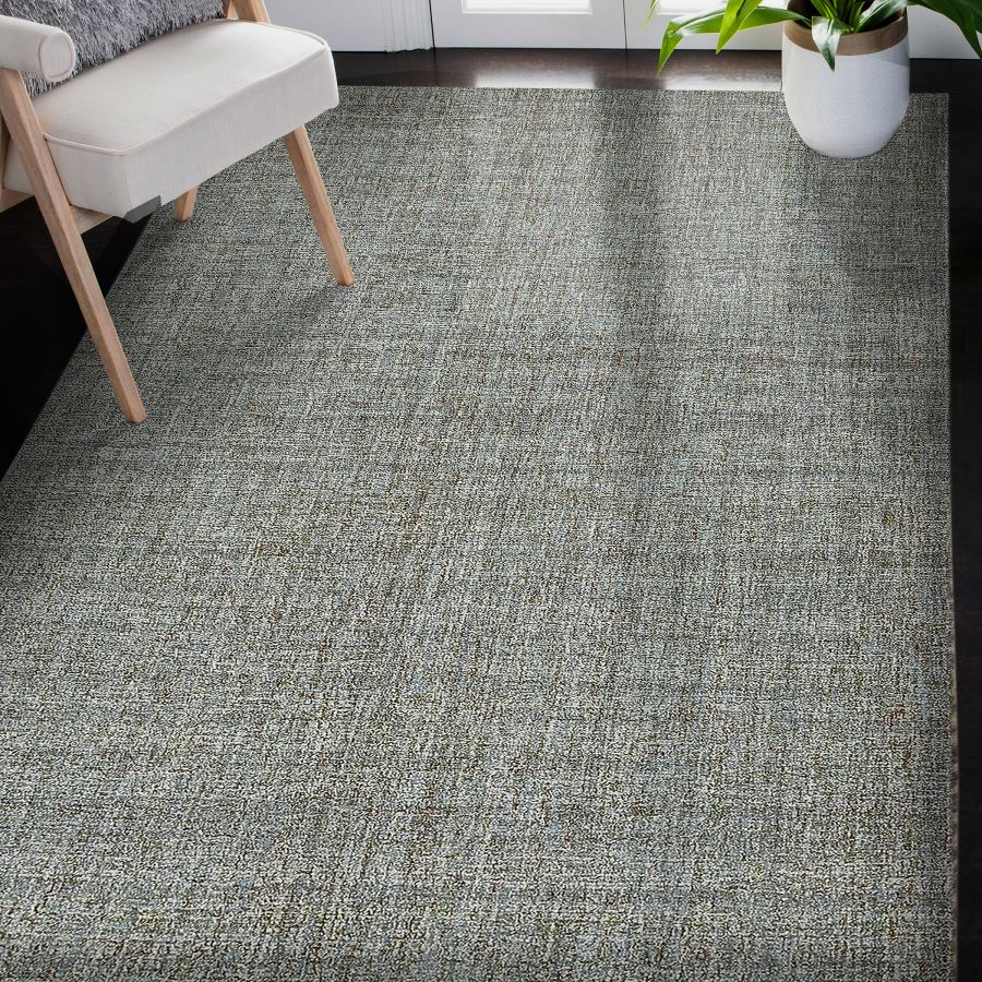 Gray textured carpet in a room with a chair and plant