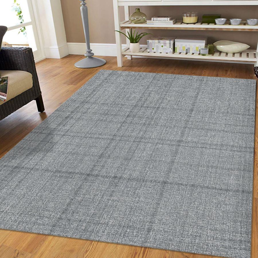 Gray checkered rug on a wooden floor with a shelf in the background