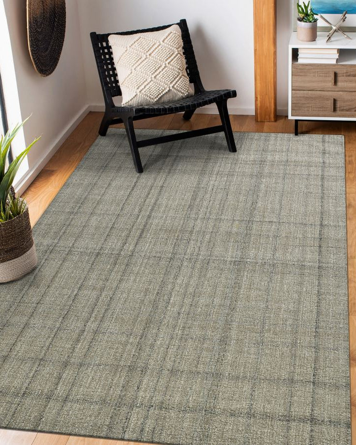 Green checkered rug in a room with a chair and plant