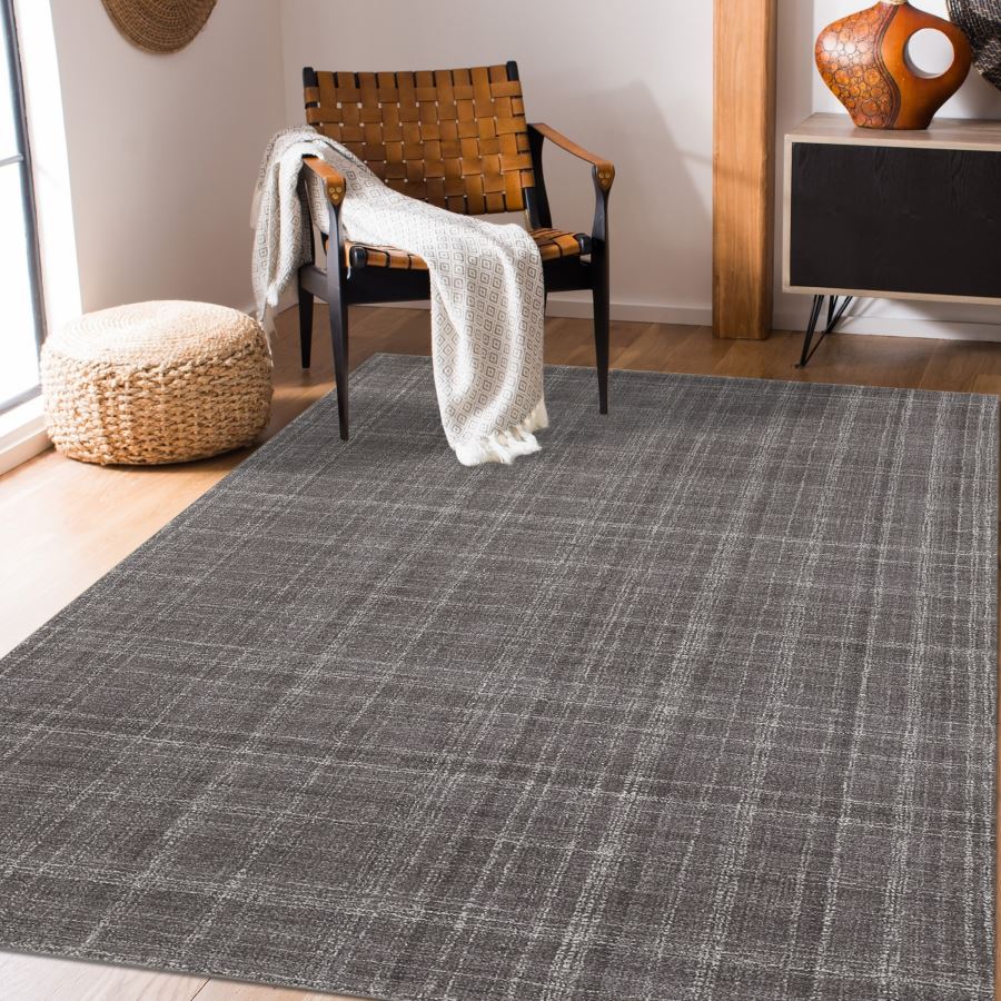Gray checkered rug in a room with a chair and ottoman.