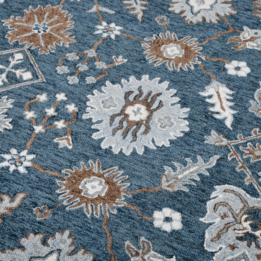 Close-up of a floral patterned rug with blue, brown, and white colors.