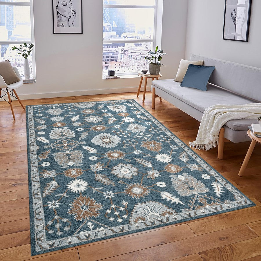 Living room with a floral patterned rug on wooden floors, a sofa, and decorative elements.
