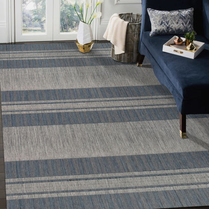 Living room with a blue and gray striped carpet, navy sofa, and decorative items.