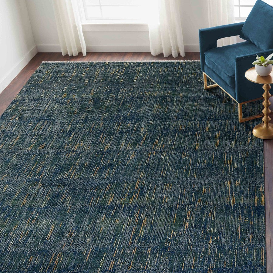 Blue textured rug in a room with a blue chair and white curtains.