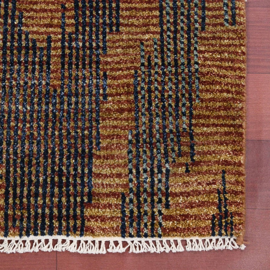 Textured brown and black patterned rug with white fringe on a red background