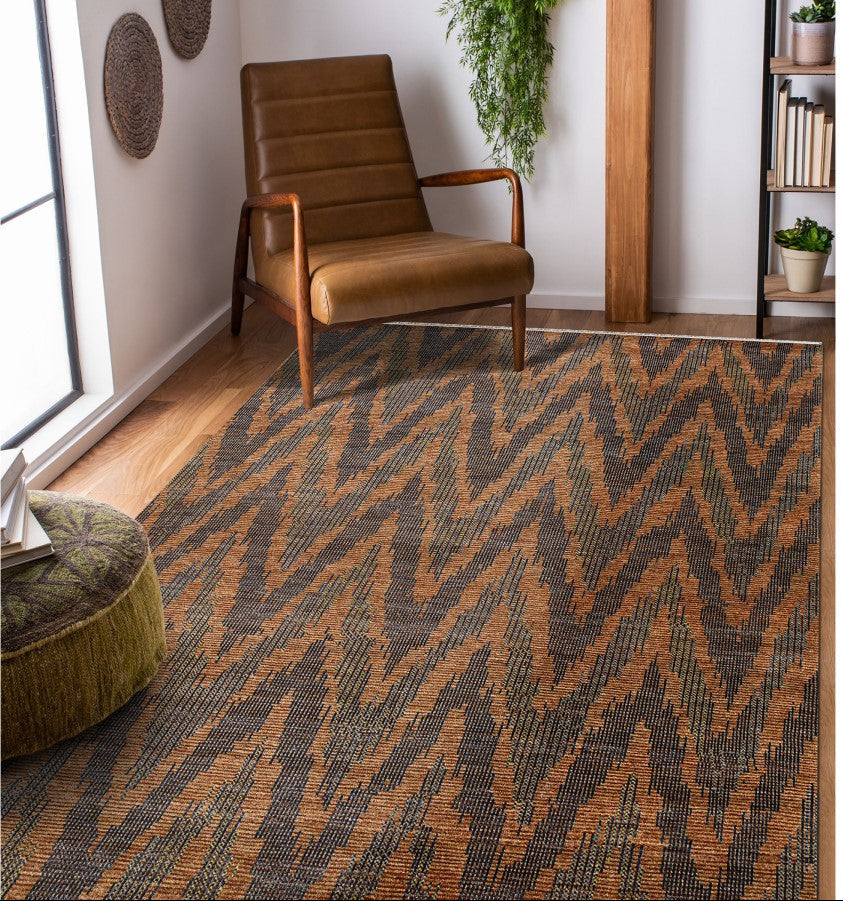 Patterned rug with zigzag design in a room with a brown armchair and bookshelf.