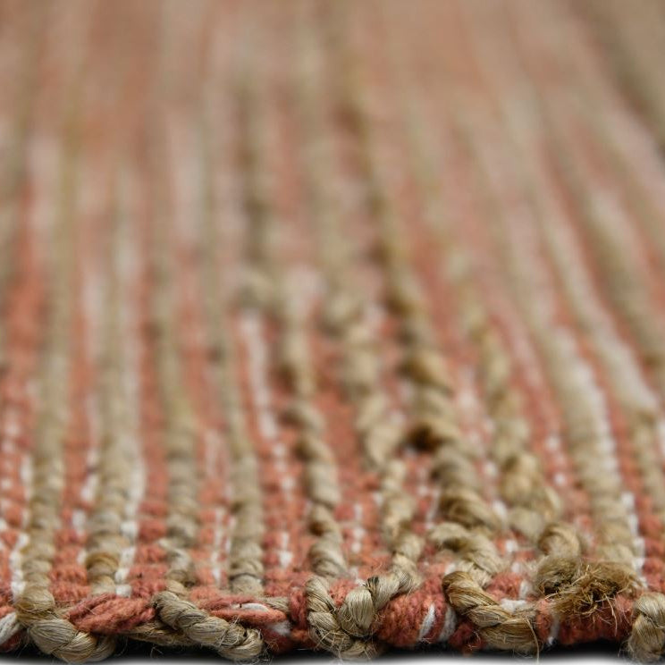 Close-up of a textured rug with a striped pattern on a white background