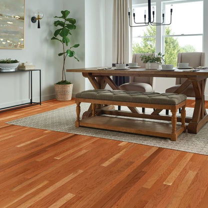 Dining room with wooden table and bench, plants, and large window.