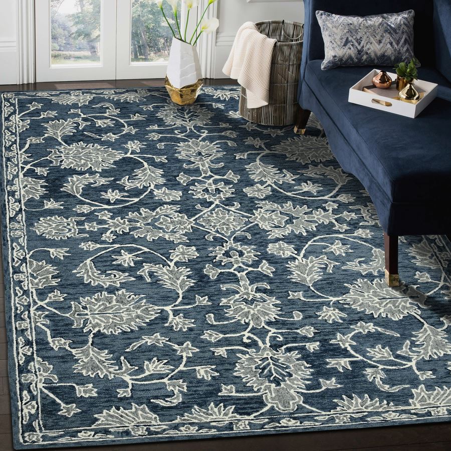 Blue floral patterned rug in a living room setting with a couch and decor items.