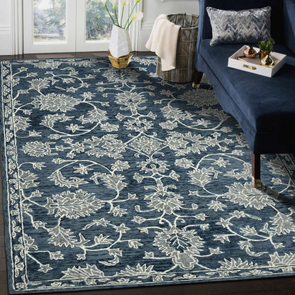 Blue floral patterned rug in a living room setting with a couch and decor items.