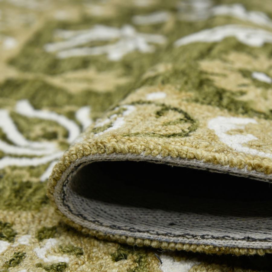 Close-up of a green patterned rug with a rolled edge.