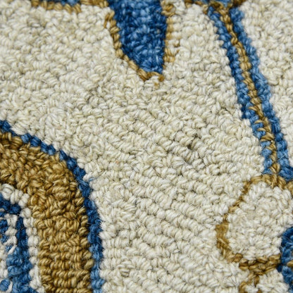Close-up of a textured rug with geometric pattern in beige, blue, and brown.