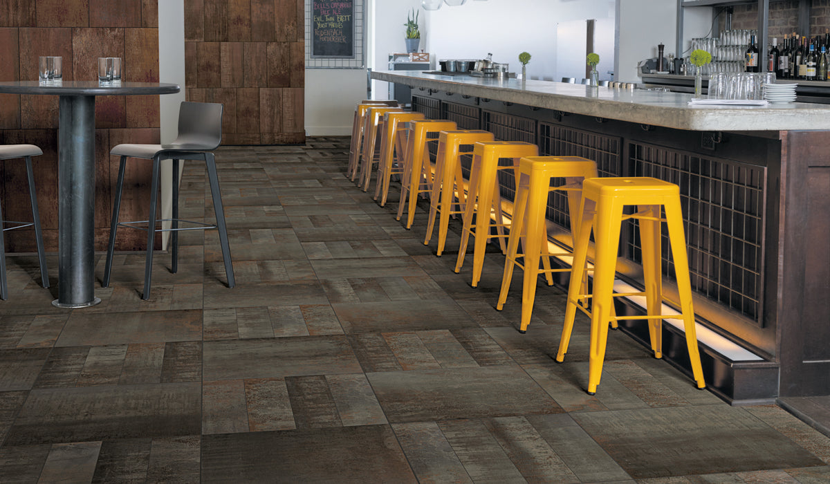 Row of yellow bar stools in a modern bar setting with wooden flooring.