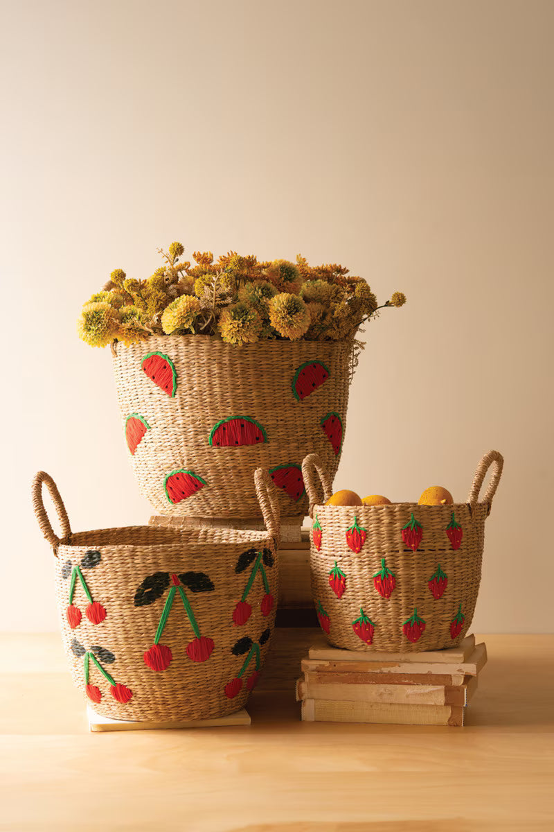 Set of 3 woven baskets with fruit patterns on a wooden surface