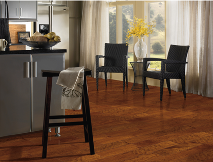 Modern kitchen with wooden flooring, black chairs, and a window with curtains.