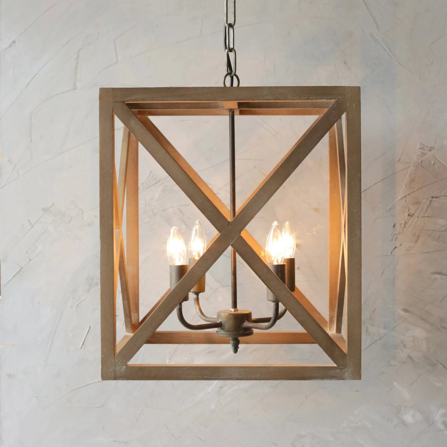 Wooden pendant light fixture with three lights on a textured wall background
