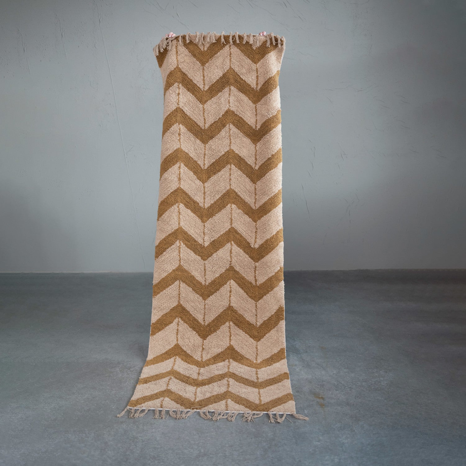 Chevron patterned blanket draped over a stand against a gray background