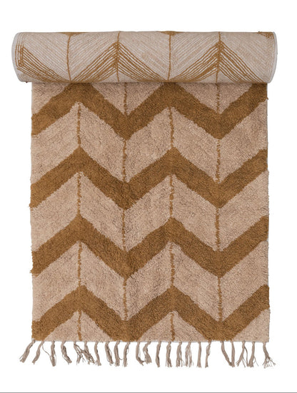 Chevron patterned rug with fringes on a white background