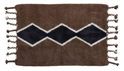 Woven rug with zigzag pattern and tassels on a white background