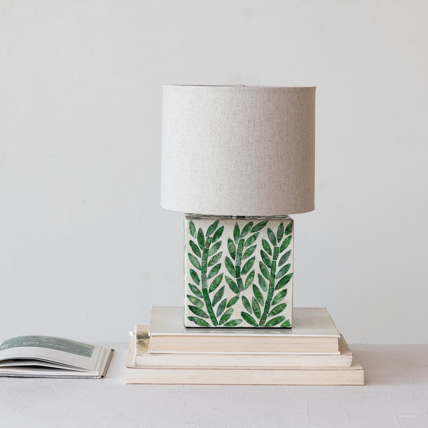 Table lamp with green leaf pattern on a white surface