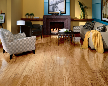 Living room with wooden floor, sofa, armchair, and decorative items.