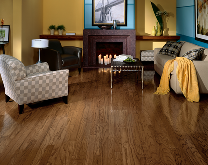 Living room with wooden floor, sofa, armchair, and fireplace.