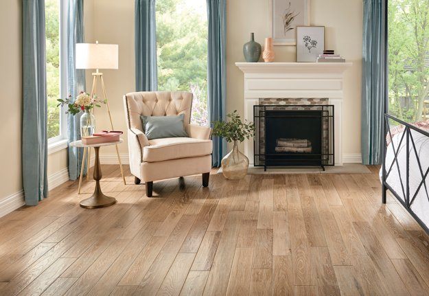 Living room with wooden flooring, armchair, and fireplace.