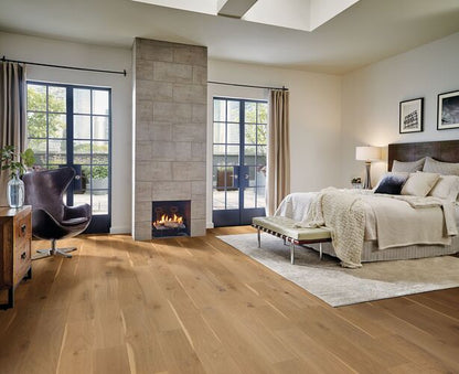Modern bedroom with wooden floor, fireplace, and large windows.