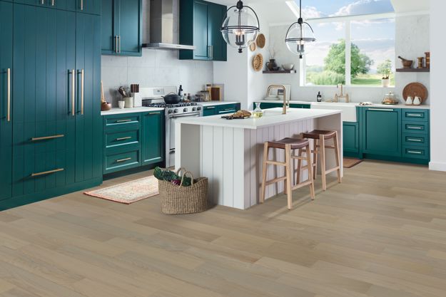 Modern kitchen with teal cabinets and a white island.
